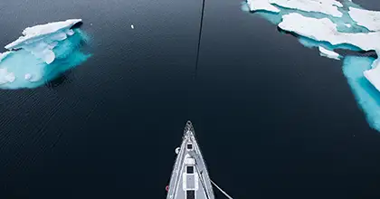 yacht by iceberg in svalbard