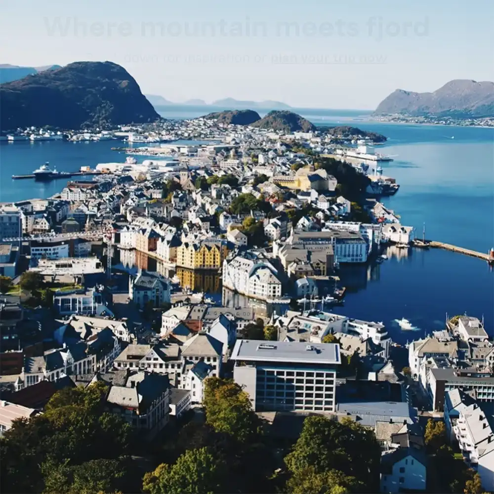 A stunning aerial view of a town in Norway, where colorful Art Nouveau buildings meet deep blue fjords and surrounding mountains. The vibrant coastal city is a gateway to Norway’s breathtaking western coastline and offshore sailing adventures.
